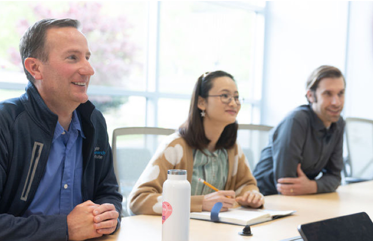 Group of people sitting around a conference table and talking